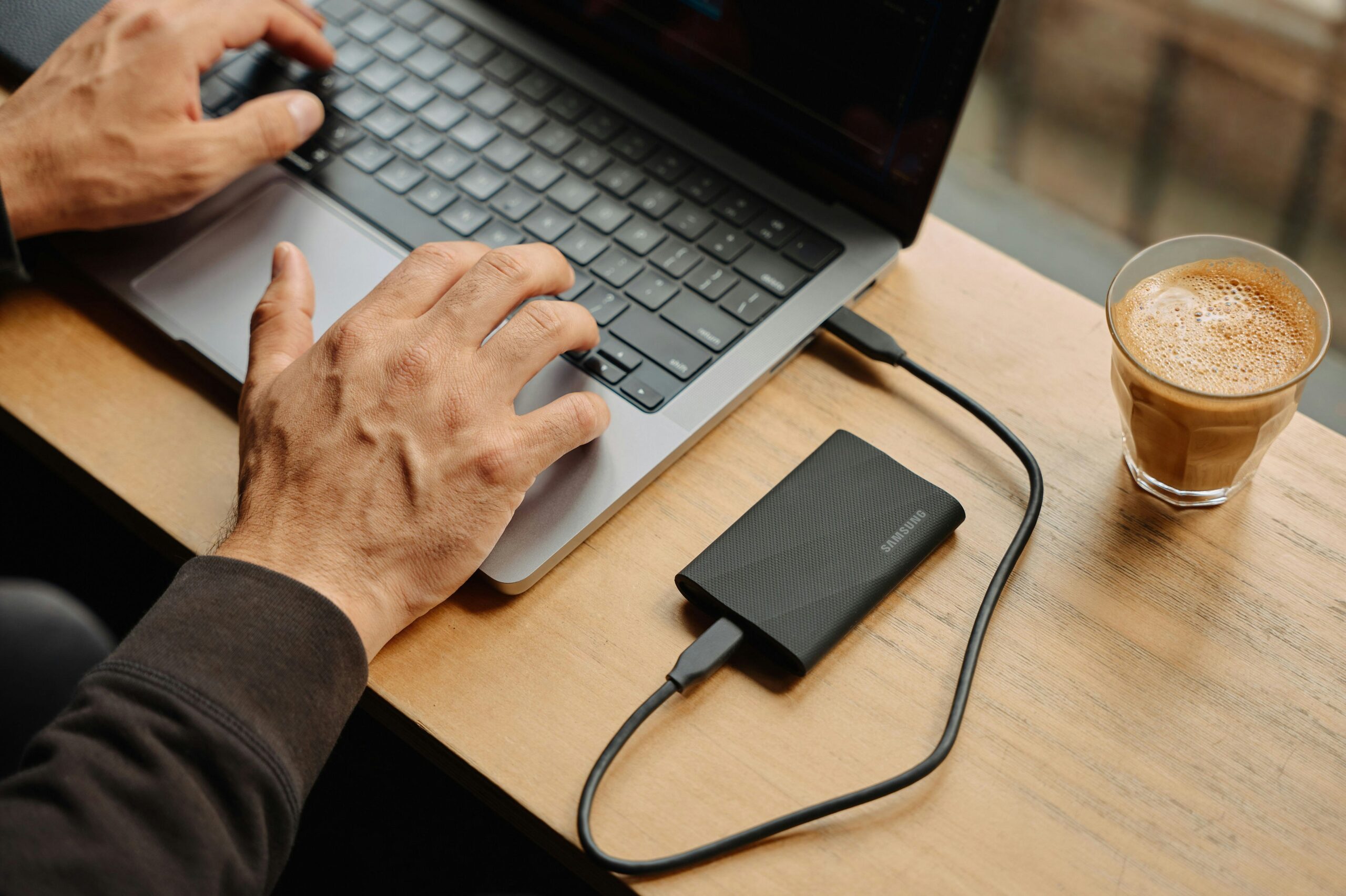 How-Much-Device-Storage-You-Need_-A-Comprehensive-Guide-scaled.jpg A man sitting at a table using a laptop computer
